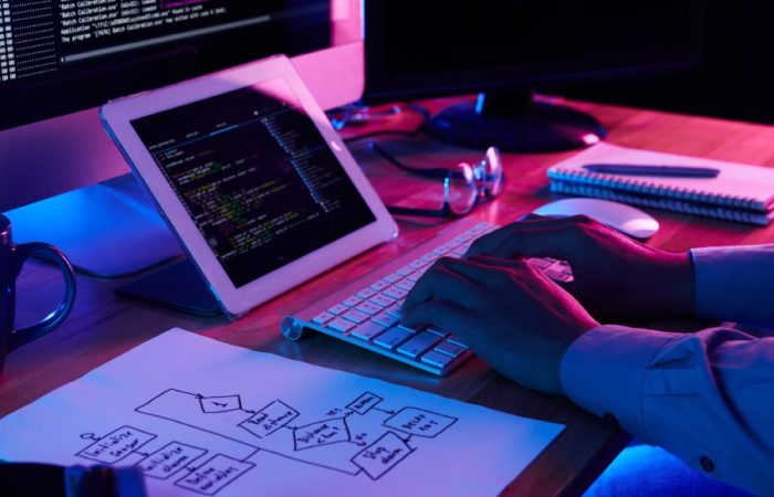 Close-up image of programer working at his desk in office to show is coding creative
