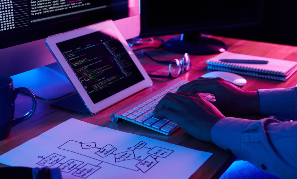 Close-up image of programer working at his desk in office to show is coding creative